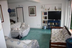 a living room with couches and a flat screen tv at Casa sul mare in Procchio