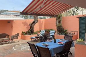 a table with chairs and an umbrella on a patio at Casa sul mare in Procchio