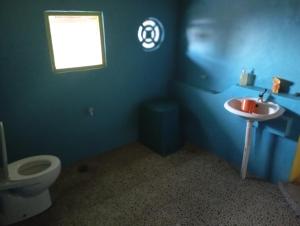 a blue bathroom with a sink and a toilet at sunrise seasports in Iboih