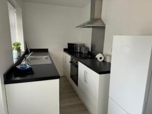 a small kitchen with a sink and a refrigerator at Holly House- 2 Bed in Whitehaven