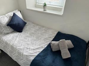 a bed with a towel on it in a room at Holly House- 2 Bed in Whitehaven