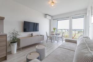 ein Wohnzimmer mit einem Sofa, einem TV und einem Tisch in der Unterkunft Cozy apartment near city centrum and Bratislava airport in Prievoz