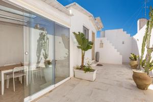 a patio with potted plants and a dining table at Clara Domus in Gallipoli