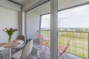 a room with a balcony with a table and chairs at Cozy apartment near city centrum and Bratislava airport in Prievoz