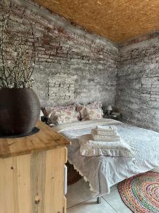 um quarto com uma cama e um vaso sobre uma mesa em Domki nad rzeką Ełk em Prostki