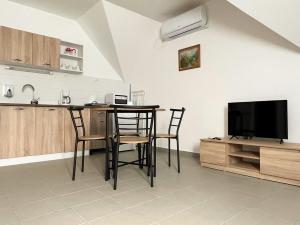 cocina con mesa y sillas y TV en Thermal Camping Zalakaros, en Zalakaros