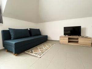 a living room with a blue couch and a flat screen tv at Thermal Camping Zalakaros in Zalakaros