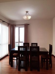 ein Esszimmer mit einem Tisch, Stühlen und einem Fenster in der Unterkunft LAKNA HOUSE in Colombo