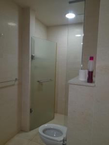 a bathroom with a toilet and a glass shower stall at LAKNA HOUSE in Colombo