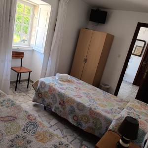 sypialnia z 2 łóżkami, komodą i oknem w obiekcie Pensión Rural para Peregrinos "AREAL" w mieście Padrón