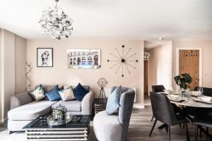 uma sala de estar com um sofá, uma mesa e um relógio em Spacious & Modern 2 Bed Apartment in Manchester em Manchester