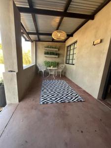 un patio con mesa, sillas y alfombra en Frere Guesthouse en Ermelo