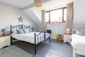 1 dormitorio con 2 camas y ventana en Rovers' Retreat Whitby George Street, en Whitby