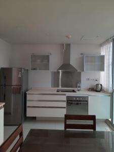 Il comprend une cuisine blanche équipée d'une cuisinière et d'un réfrigérateur. dans l'établissement LAKNA HOUSE, à Colombo