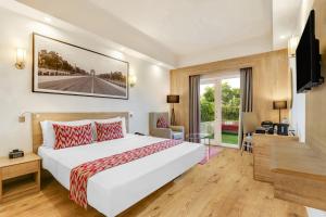 a hotel room with a bed and a television at Lemon Tree Premier City Center in Gurgaon