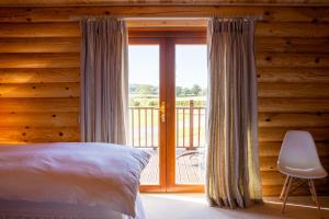 Foxton的住宿－Owl's Nest，一间卧室设有一张床和一个滑动玻璃门