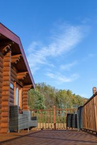 a log cabin with two chairs on a deck at Owl's Nest in Foxton