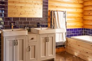 Foxton的住宿－Owl's Nest，浴室配有2个盥洗盆和1个浴缸。
