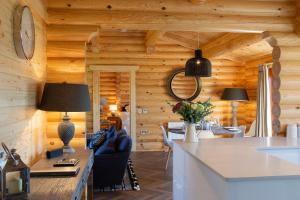 a kitchen and dining room with wooden walls at Owl's Nest in Foxton
