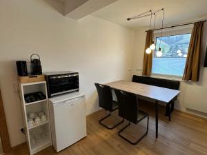uma cozinha com uma mesa e cadeiras e um micro-ondas em Willi‘s Studio em Saalbach-Hinterglemm