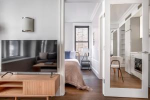um quarto branco com uma cama e uma sala de estar em UWS 1br w elevator doorman gym nr Central Park NYC-963 em Nova York