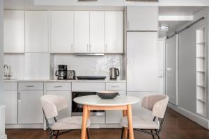 uma cozinha com armários brancos e uma mesa e cadeiras em UWS 1br w elevator doorman gym nr Central Park NYC-963 em Nova York