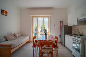 een keuken en eetkamer met een tafel en een bank bij Casa Vacanze Ferrando in Pietra Ligure
