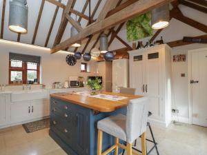 a kitchen with a blue island with a wooden counter top at The Old Byre in Salisbury
