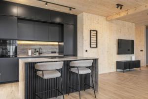 a kitchen with a bar with two stools at Luxury Golden Circle Villa in Grímsnes og Grafningshreppur
