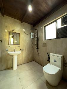 a bathroom with a toilet and a sink at Eco Knuckles Holiday Lodge in Kandy