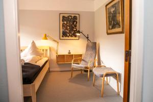 a bedroom with a bed and two chairs in it at Fuglsang Herregaard Hotel in Nykøbing Falster
