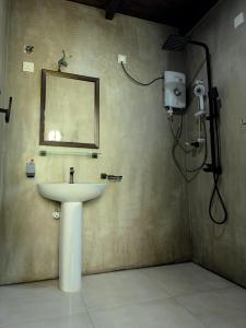 baño con lavabo y espejo en la pared en Eco Knuckles Holiday Lodge, en Kandy
