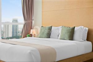 1 dormitorio con 1 cama blanca grande y ventana en Cera by Kozystay - 2BR - Mall Access - Kemang, en Yakarta