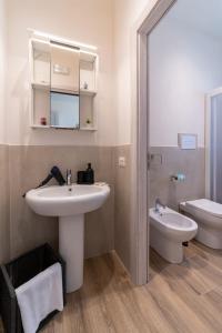 een badkamer met een wastafel, een toilet en een spiegel bij Baglio Tuzza in Marsala