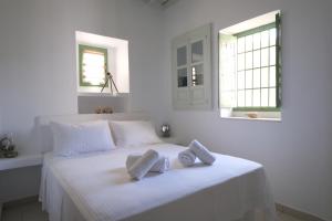 a white bedroom with a bed with towels on it at Nymph Klido in Kanakis