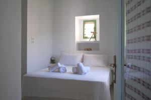 Un dormitorio con una cama blanca con toallas. en Nymph Klido, en Kanakis