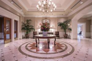 La Grande Residence at the Sutton Place Hotel في فانكوفر: لوبي كبير مع طاولة عليها زهور