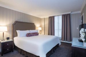 uma grande cama branca num quarto de hotel em La Grande Residence at the Sutton Place Hotel em Vancouver