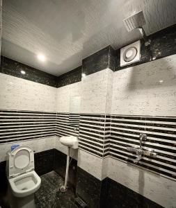 a bathroom with a toilet and a sink at HOTEL VIA GANGA INN ! VARANASI ! FULLY AIR-CONDITIONED HOTEL AT PRIME LOCATION WITH ROOFTOP GANGES VIEW! 2 Min walking distance from ASSI GHAT ,NEAR KASHI VISHWANATH TEMPLE in Varanasi
