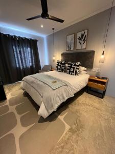 una camera con un grande letto e un ventilatore a soffitto di Frere Guesthouse a Ermelo