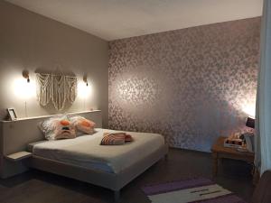 a bedroom with a bed and a wall with flowers at LE DINANGA in Léran