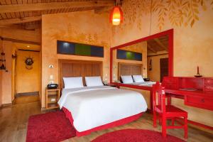 1 dormitorio con 2 camas y escritorio rojo en Luna Volcán, Adventure SPA en Baños