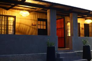 a house with a red door and two windows at Frere Guesthouse in Lothair