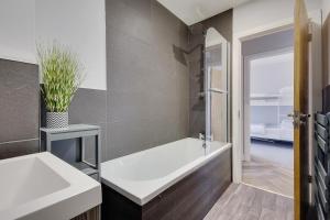 a bathroom with a white bath tub and a sink at Ashley Road Apartment 2 in Poole