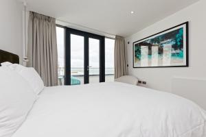 a white bedroom with a large bed and a window at Gorgeous 2 Bed Apartment with Stunning Sea Views with Free Parking and Fast Internet in Ramsgate