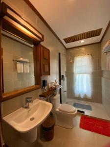 une salle de bain avec un lavabo blanc et des toilettes dans l'établissement EL RIO Y MAR RESORT, à Coron