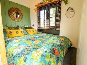 a bedroom with a bed with a colorful comforter at Portland in Retford