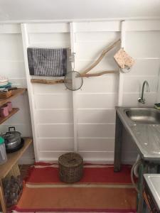 uma pequena cozinha com um lavatório e um lavatório em The white house em Ko Phangan