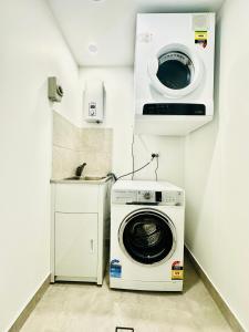 a washer and dryer in a small room at The Residences at The Peninsula in Gold Coast