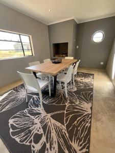 comedor con mesa de madera y sillas en Frere Guesthouse en Ermelo